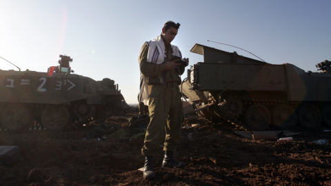 Un soldat israélien utilise un moment de répit pour prier. Un soldat israélien utilise un moment de répit pour prier.