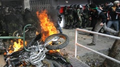 Une motocyclette des forces de l'ordre incendiée par les manifestants. Une motocyclette des forces de l'ordre incendiée par les manifestants.