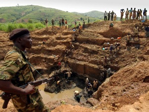 Un combattant de l'Union des patriotes congolais, en Ituri, surveille les travailleurs d'une mine d'or. En RDC, les mines enrichissent davantage les groupes armées et les compagnies étrangères que les Congolais. Un combattant de l'Union des patriotes congolais, en Ituri, surveille les travailleurs d'une mine d'or. En RDC, les mines enrichissent davantage les groupes armées et les compagnies étrangères que les Congolais.