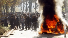 Des jeunes se tiennent devant un véhicule incendié à Nanterre, près de Paris. Des jeunes se tiennent devant un véhicule incendié à Nanterre, près de Paris.