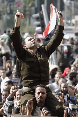 Un homme portant un uniforme de capitaine de l'armée égyptienne est porté par la foule rassemblée lundi place Tahrir. Un homme portant un uniforme de capitaine de l'armée égyptienne est porté par la foule rassemblée lundi place Tahrir.