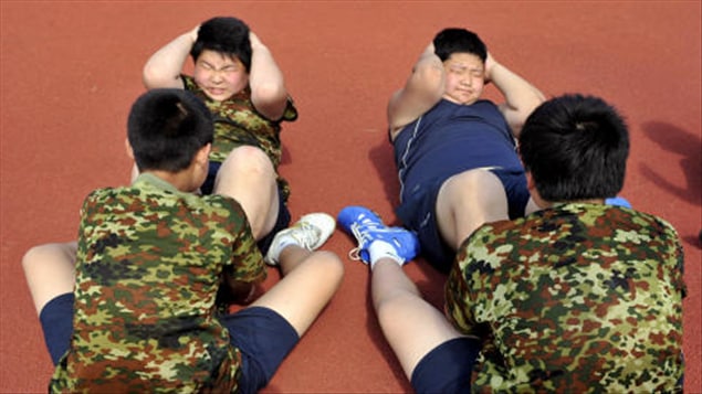Des enfants obèses chinois peinent à faire des redressements assis. Des enfants obèses chinois peinent à faire des redressements assis.
