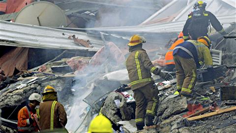 Les pompiers fouillent dans les débris des immeubles détruits. Les pompiers fouillent dans les débris des immeubles détruits.