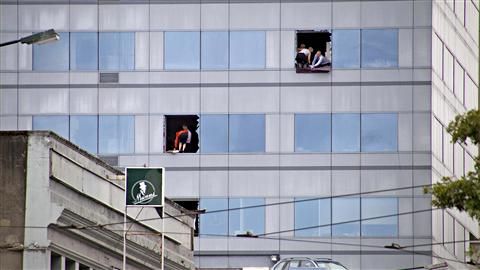 Des employés brisent des fenêtres pour accueillir les secours qui viendront en échelles. Des employés brisent des fenêtres pour accueillir les secours qui viendront en échelles.