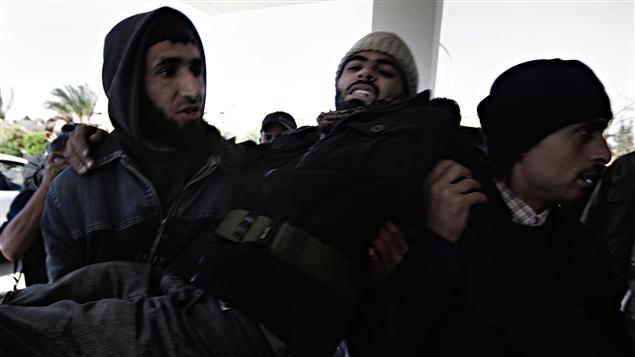 Un insurgé libyen est transporté à l'hôpital de Ras Lanouf. Un insurgé libyen est transporté à l'hôpital de Ras Lanouf.