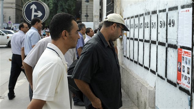 Des passants regardent des pancartes électorales à Tunis, le 1er octobre 2011. Des passants regardent des pancartes électorales à Tunis, le 1er octobre 2011.