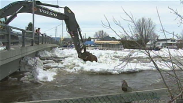 Travaux d'une excavatrice pour dégager une partie des glaces accumulées Travaux d'une excavatrice pour dégager une partie des glaces accumulées