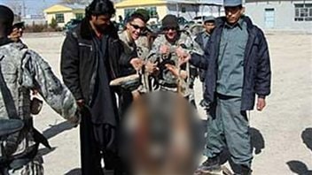 Des soldats américains et des membres des forces afghanes posent avec les restes d'un kamikaze. Des soldats américains et des membres des forces afghanes posent avec les restes d'un kamikaze.