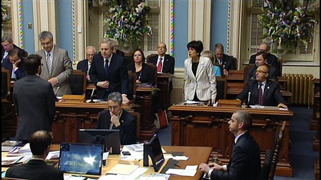 Le premier ministre Jean Charest se lève pour appuyer le principe du projet de loi spéciale déposé par son gouvernement. À gauche, le ministre de la Justice, Jean-Marc Fournier; à droite, la ministre de l'Éducation, Michelle Courchesne. Le premier ministre Jean Charest se lève pour appuyer le principe du projet de loi spéciale déposé par son gouvernement. À gauche, le ministre de la Justice, Jean-Marc Fournier; à droite, la ministre de l'Éducation, Michelle Courchesne.