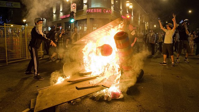Des manifestants brûlent des barricades et des cônes de signalisation routière au centre-ville de Montréal. Des manifestants brûlent des barricades et des cônes de signalisation routière au centre-ville de Montréal.