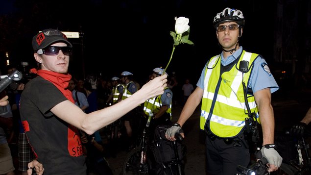 Un manifestant offre une fleur à un policier. Un manifestant offre une fleur à un policier.