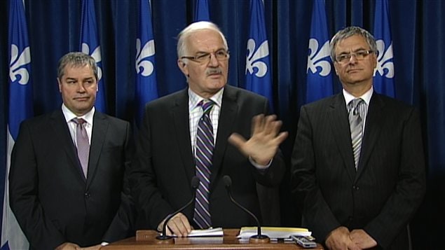 Le juriste Jean-Pierre Ménard, entouré des ministres Yves Bolduc et Jean-Marc Fournier Le juriste Jean-Pierre Ménard, entouré des ministres Yves Bolduc et Jean-Marc Fournier