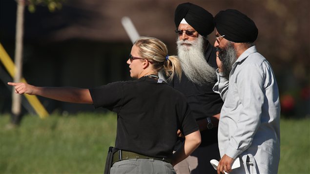 Une agente de police donne des directives aux gens près du temple sikh d'Oak Creek, le 5 août 2012 Une agente de police donne des directives aux gens près du temple sikh d'Oak Creek, le 5 août 2012
