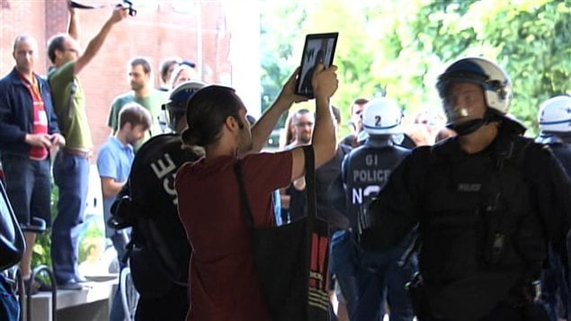 Un étudiant qui prend des photos des policiers sur le point d'être interpellé. Un étudiant qui prend des photos des policiers sur le point d'être interpellé.