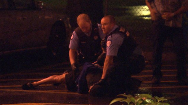 Des agents du SPVM menottent le suspect plaqué au sol à la suite de son arrestation. Des agents du SPVM menottent le suspect plaqué au sol à la suite de son arrestation.