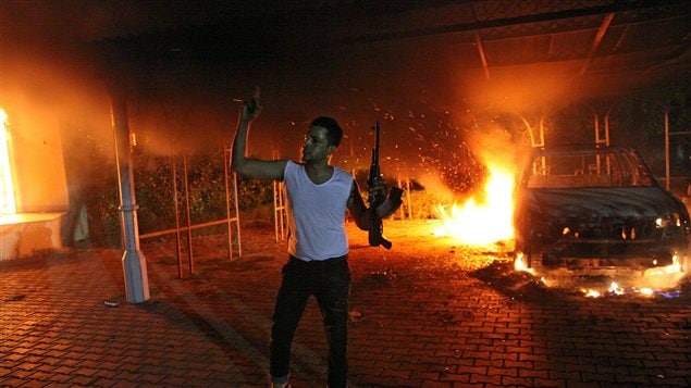 Un homme armé montre son arme alors que le consulat américain brûle à Benghazi, le 11 septembre 2012. Un homme armé montre son arme alors que le consulat américain brûle à Benghazi, le 11 septembre 2012.