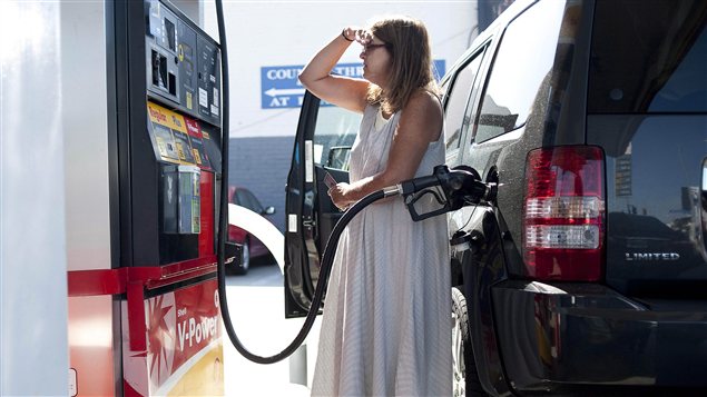 Une femme fait le plein d'essence. Une femme fait le plein d'essence.