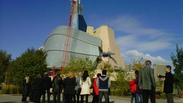 La dernière pièce de verre sur le point d'être posée sur l'édifice du Musée canadien pour les droits de la personne. La dernière pièce de verre sur le point d'être posée sur l'édifice du Musée canadien pour les droits de la personne.
