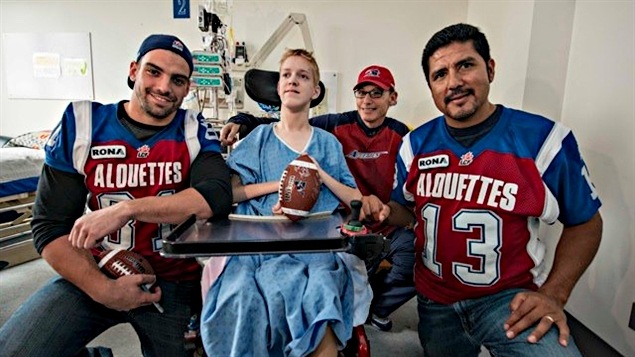 Patrick Lavoie, Marc Trestman et Anthony Calvillo entourent un enfant malade. Patrick Lavoie, Marc Trestman et Anthony Calvillo entourent un enfant malade.