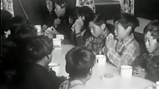 Des élèves d'un pensionnat autochtone au Canada font une prière avant leur repas. Des élèves d'un pensionnat autochtone au Canada font une prière avant leur repas.