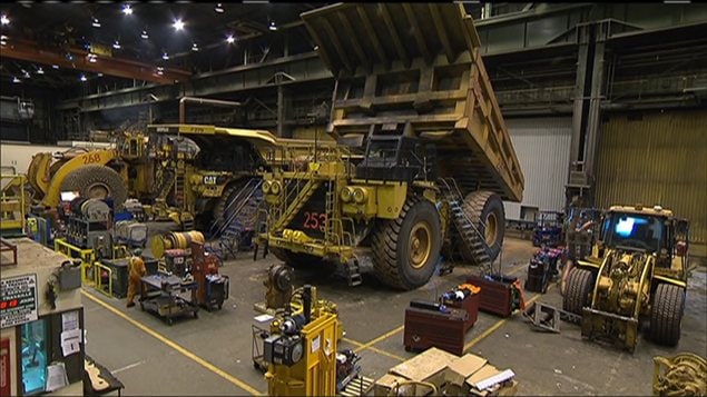 Camions et ouvriers sur un chantier du Plan Nord Camions et ouvriers sur un chantier du Plan Nord