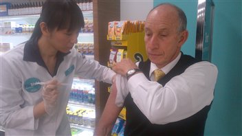 Un Torontois se fait vacciner contre la grippe dans une pharmacie. Un Torontois se fait vacciner contre la grippe dans une pharmacie.