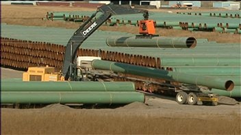 Une grue lève un tuyau de pipeline. Une grue lève un tuyau de pipeline.