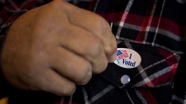 Un homme posant un autocollant « I Voted » sur sa chemise après avoir mis le bulletin dans l'urne à Otter Creek dans l'Iowa. Un homme posant un autocollant « I Voted » sur sa chemise après avoir mis le bulletin dans l'urne à Otter Creek dans l'Iowa.