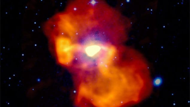 L’Image en fausses couleurs de la galaxie M 87. La lumière visible apparaît en blanc et bleu. L’émission radio est codée en jaune-orangé. Au centre, l’émission radio très intense provient du jets de particules propulsé par le trou noir. L’Image en fausses couleurs de la galaxie M 87. La lumière visible apparaît en blanc et bleu. L’émission radio est codée en jaune-orangé. Au centre, l’émission radio très intense provient du jets de particules propulsé par le trou noir.