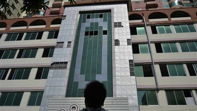 Un homme regarde la façade du plus grand immeuble de Mandalay, dont certains fenêtres sont tombées à la suite du séisme Un homme regarde la façade du plus grand immeuble de Mandalay, dont certains fenêtres sont tombées à la suite du séisme