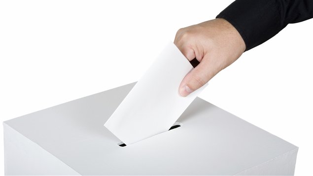 Un électeur place son bulletin de vote dans l'urne Un électeur place son bulletin de vote dans l'urne