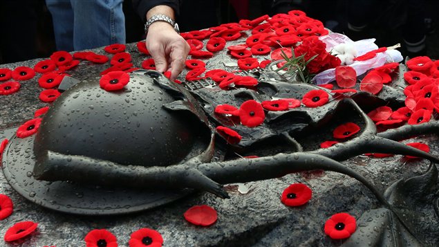 Des Canadiens déposent leur coquelicot sur la tombe du soldat inconnu à Ottawa. Des Canadiens déposent leur coquelicot sur la tombe du soldat inconnu à Ottawa.