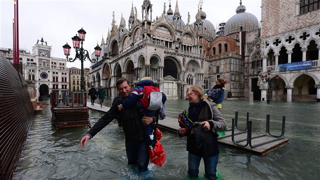 Des passants dans une rue inondée de Venise. Des passants dans une rue inondée de Venise.