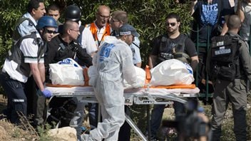 Des secouristes israéliens évacuent le corps d'une des trois victimes d'un tir de roquette en provenance de la Palestine. Des secouristes israéliens évacuent le corps d'une des trois victimes d'un tir de roquette en provenance de la Palestine.