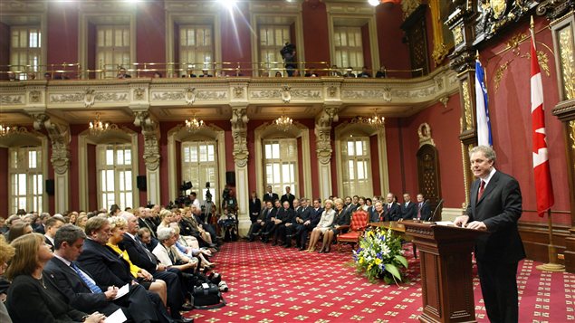 Jean Charest dans la salle du conseil législatif. On peut y voir le drapeau canadien. Jean Charest dans la salle du conseil législatif. On peut y voir le drapeau canadien.