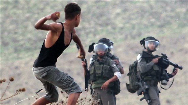 Un jeune Palestinien tire une roche aux soldats israéliens le 18 novembre 2012. Un jeune Palestinien tire une roche aux soldats israéliens le 18 novembre 2012.