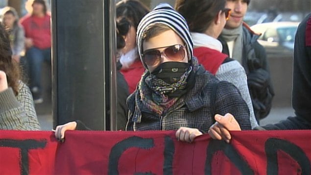 Un manifestant tenant avec ses pairs une bannière sur laquelle on peut lire : « La crise est globale, la lutte est mondiale, résistance générale. » Un manifestant tenant avec ses pairs une bannière sur laquelle on peut lire : « La crise est globale, la lutte est mondiale, résistance générale. »