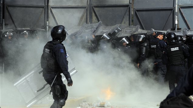 Des policiers antiémeute tentent d'empêcher des manifestants de mettre à terre une clôture de sécurité à l'extérieur du Parlement lors de l'assermentation du président. Des policiers antiémeute tentent d'empêcher des manifestants de mettre à terre une clôture de sécurité à l'extérieur du Parlement lors de l'assermentation du président.