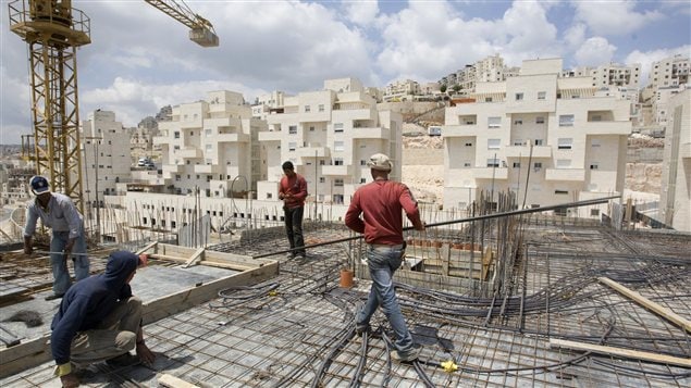 Des travailleurs érigent un complexe d'habitation à Jerusalem-Est. Des travailleurs érigent un complexe d'habitation à Jerusalem-Est.