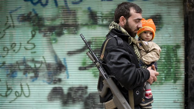 À Alep, un rebelle oprtant son fils À Alep, un rebelle oprtant son fils