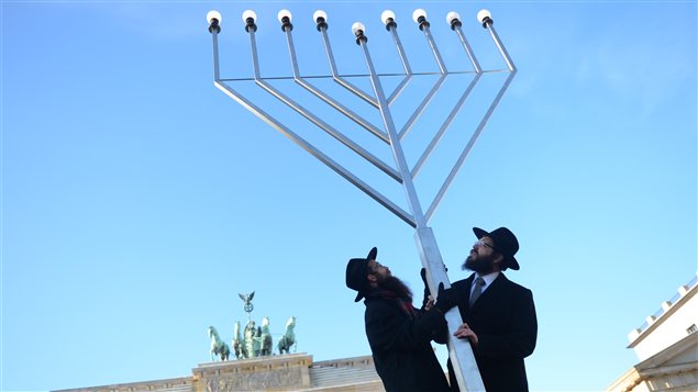 Des rabbins érigent une menorah, un chandelier à sept branches qui représente un emblème biblique. Des rabbins érigent une menorah, un chandelier à sept branches qui représente un emblème biblique.