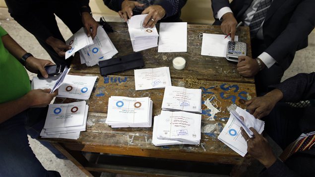 Des officiels procèdent au décompte des bulletins de vote, après le premier jour de vote sur le projet de Constitution en Égypte Des officiels procèdent au décompte des bulletins de vote, après le premier jour de vote sur le projet de Constitution en Égypte