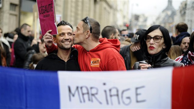 Un homme embrasse son compagnon durant la manifestation pour le projet de loi permettant le mariage et l'adoption pour les gais, à Paris. Un homme embrasse son compagnon durant la manifestation pour le projet de loi permettant le mariage et l'adoption pour les gais, à Paris.