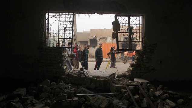 Des Irakiens observent les dommages subis par un édifice après un attentat survenu en novembre 2012, à Bagdad Des Irakiens observent les dommages subis par un édifice après un attentat survenu en novembre 2012, à Bagdad