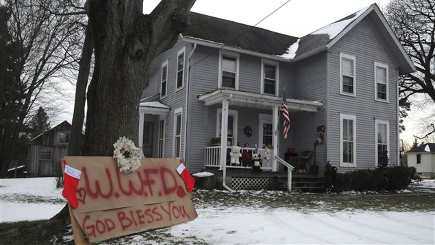 Une affiche en mémoire des victimes devant une maison de Webster, dans l'État de New York Une affiche en mémoire des victimes devant une maison de Webster, dans l'État de New York