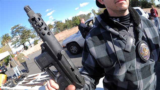 Un policier vient de récupérer une arme d'assaut lors de l'opération à Los Angeles Un policier vient de récupérer une arme d'assaut lors de l'opération à Los Angeles