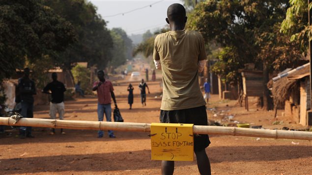 Un homme bloque une route menant à la capitale en prévision d'une éventuelle offensive des rebelles à Bangui. Un homme bloque une route menant à la capitale en prévision d'une éventuelle offensive des rebelles à Bangui.