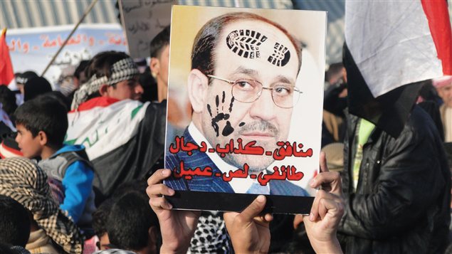 Des manifestants à Ramadi brandissant un portrait d'Al-Maliki où on peut lire « Hypocrite, menteur, sectaire, voleur, traitre » Des manifestants à Ramadi brandissant un portrait d'Al-Maliki où on peut lire « Hypocrite, menteur, sectaire, voleur, traitre »