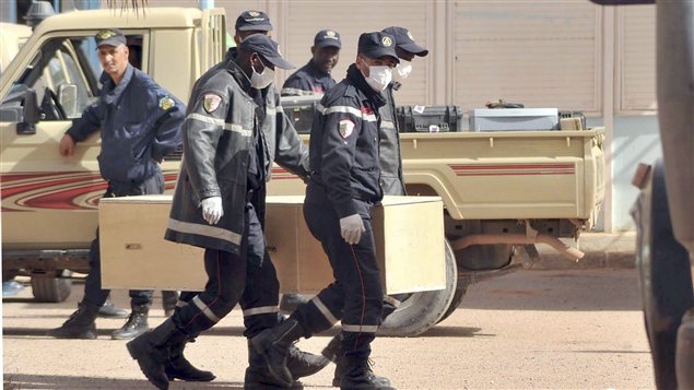 Des pompiers algériens portent un cercueil sur le complexe gazier d'In Amenas. Des pompiers algériens portent un cercueil sur le complexe gazier d'In Amenas.