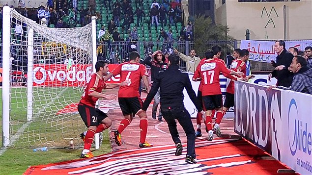 Des joueurs fuient le stade alors que les partisans commencent à s'affronter sur le terrain, le 1er février 2012 Des joueurs fuient le stade alors que les partisans commencent à s'affronter sur le terrain, le 1er février 2012